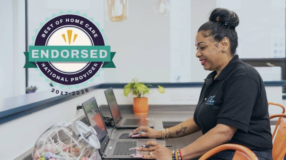 Right at Home office employee typing on a computer with a 2026 Best of Home Care Endorsed badge