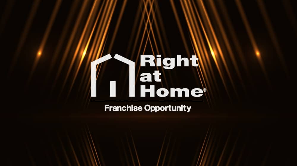 White Right at Home logo on a black background with gold lights shining in the background