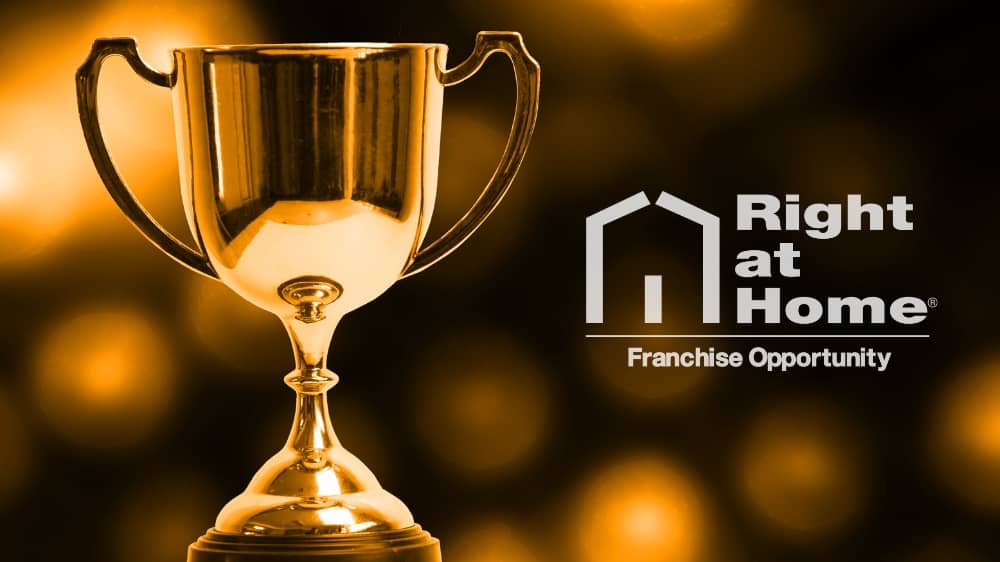 White Right at Home logo next to a plain gold trophy over a black and gold background