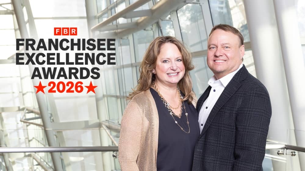 Right at Home Franchisees Scott and Kami Sjoberg standing with a Franchise Business Review 2026 Franchise Excellence Award badge