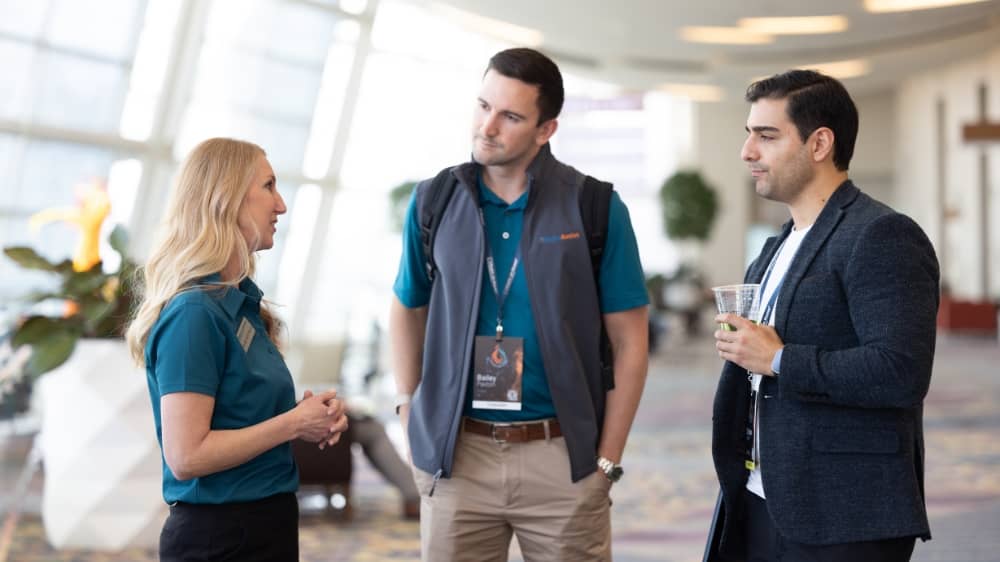 Two Right at Home Corporate employees speaking with a franchisee at annual Home Improvement Conference