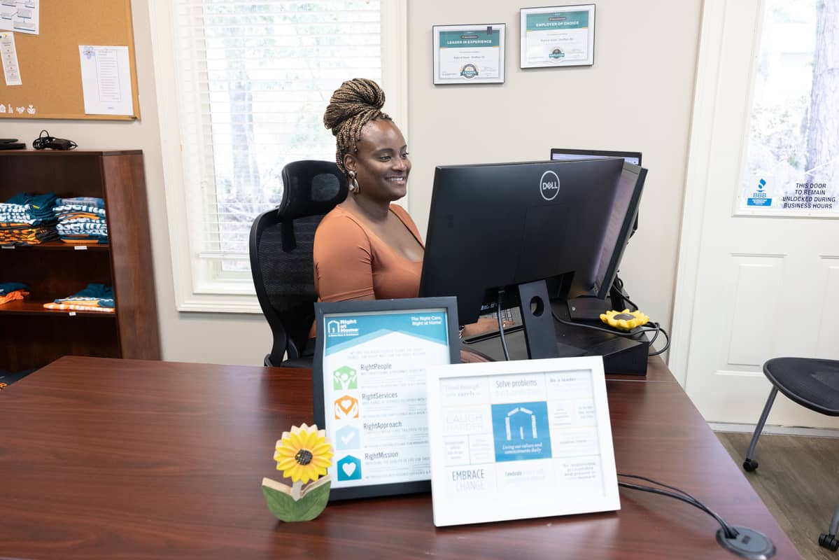Female office employee sitting at a desk and looking at her computer screen