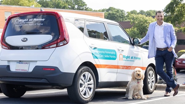 Right at Home franchisee Ken Helmuth standing next to a Right at Home branded care