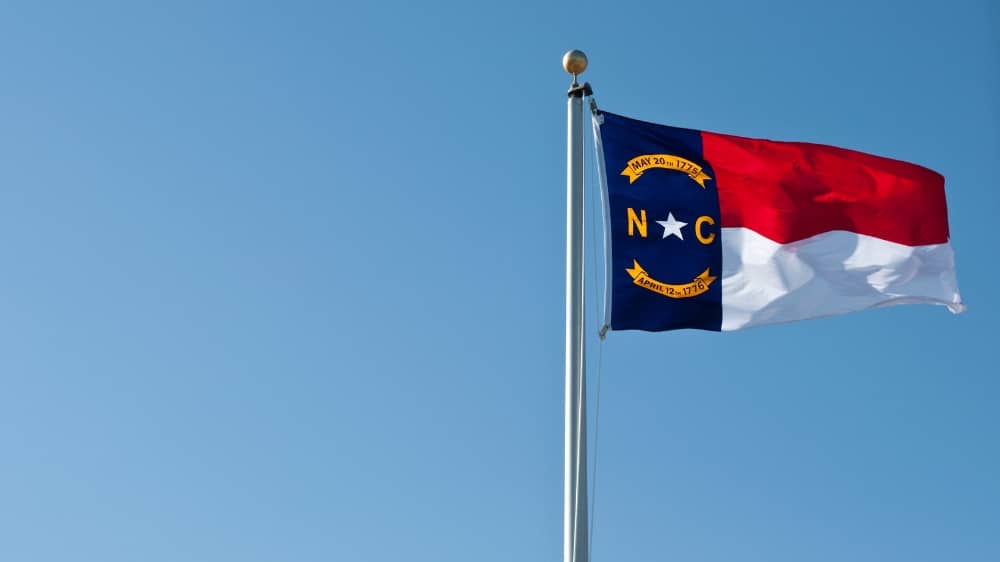 North Carolina state flag against a clear blue sky