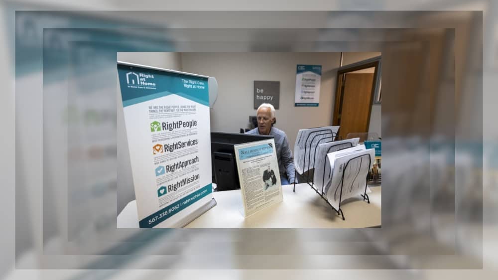 Right at Home franchsiee John Baldwin sitting at the reception desk in his office