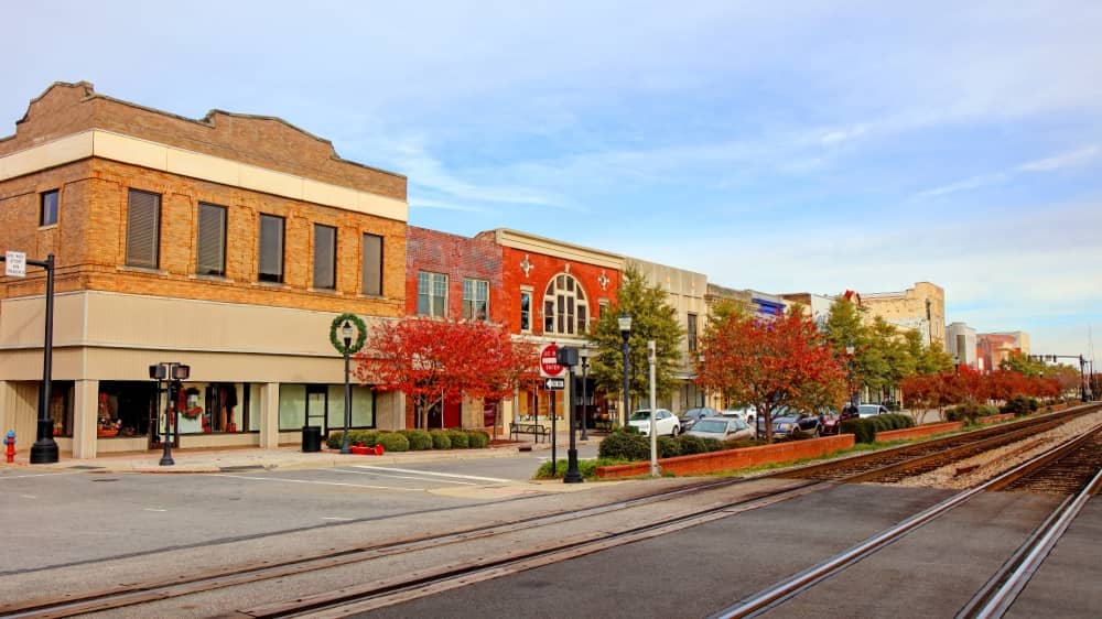 Small town street with a set of train tracks running down the middle of the street in Rocky Mount, North Carolina