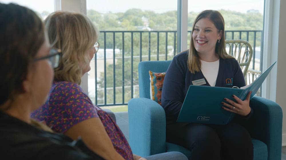 A female Right at Home representative is meeting with a potential female client and her adult daughter in a living room