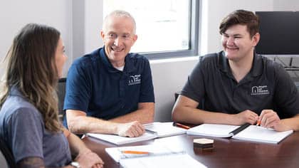 three right at home office staff members sitting at a table having a conversation 