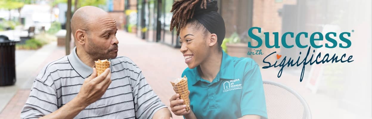 Female Right at Home caregiver enjoying ice cream with a client