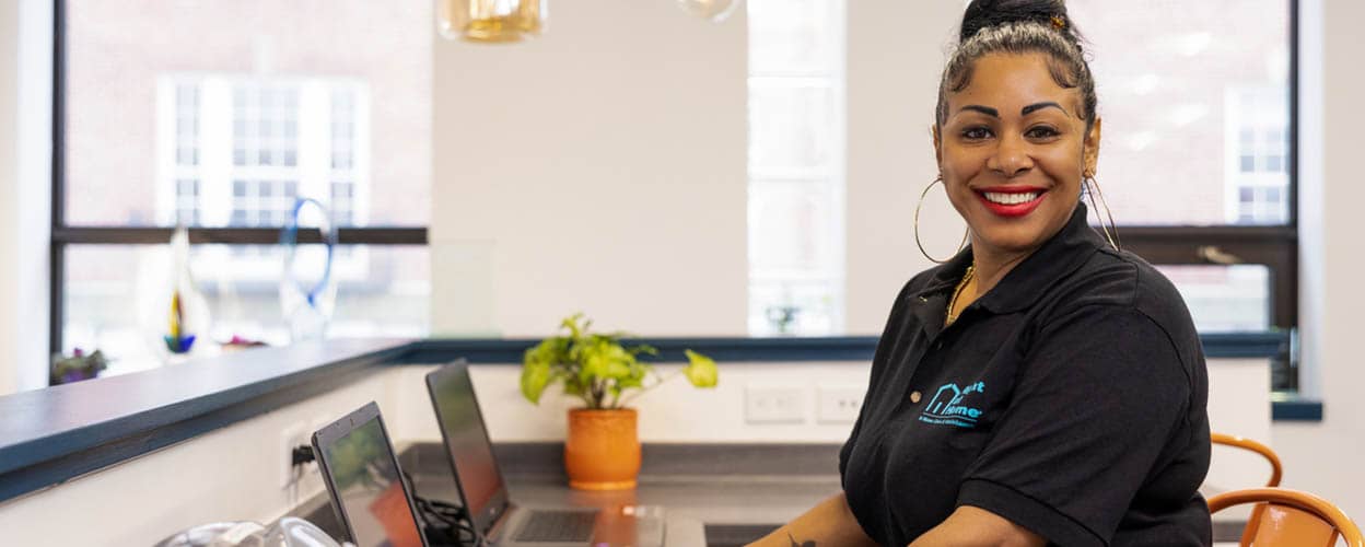 A female Right at Home staff member is sitting at a computer in the office