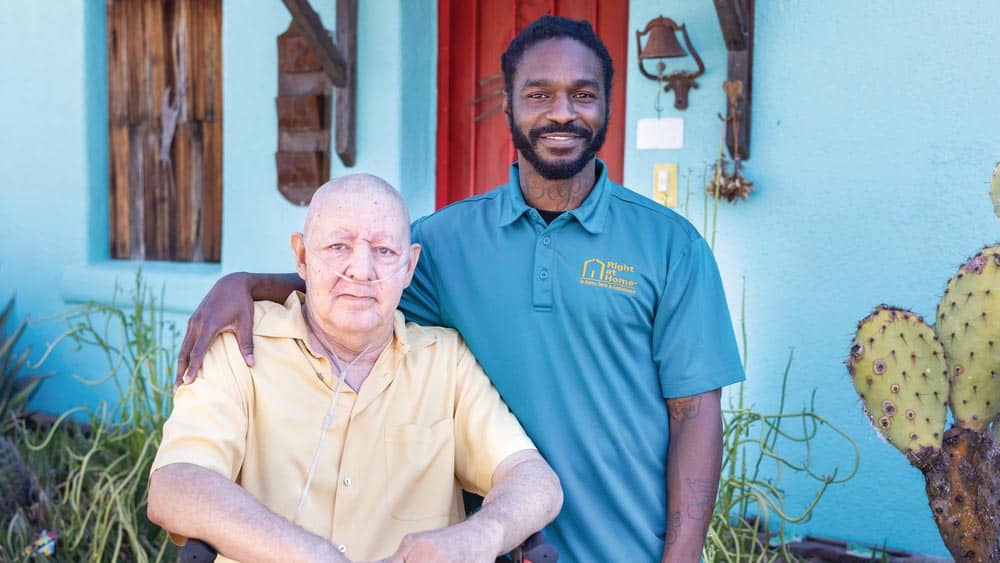 Male Right at Home Caregiver standing with his arm around his senior male client outside
