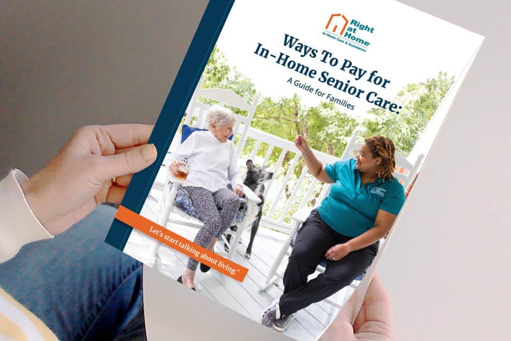 a photo of someone holding a ways to pay for in-home senior care guide